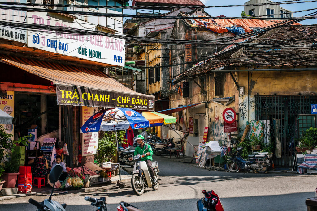 Vietnamese Photo art print travel poster of a grab bike on a corner in Old Quarter Hanoi