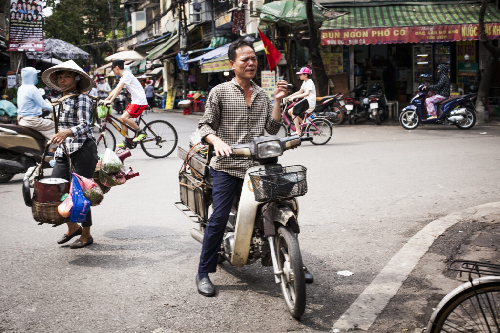 Vietnamese travel photography art print of a man smoking. cigarette on his Honda dream bike