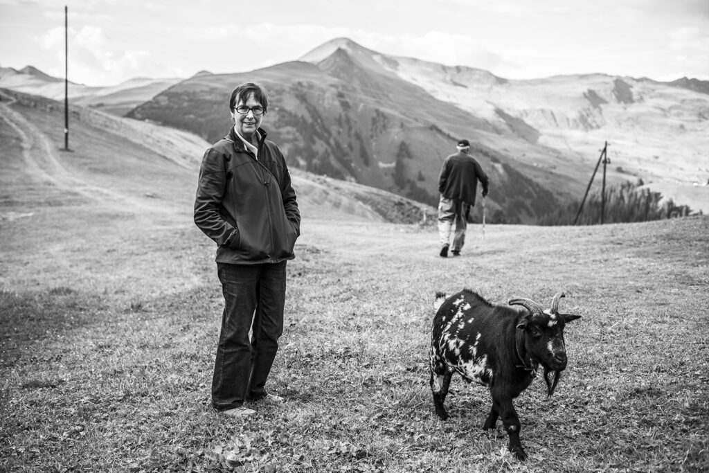 Photo of a woman and her goat, walking in the Alps Medergen Switzerland