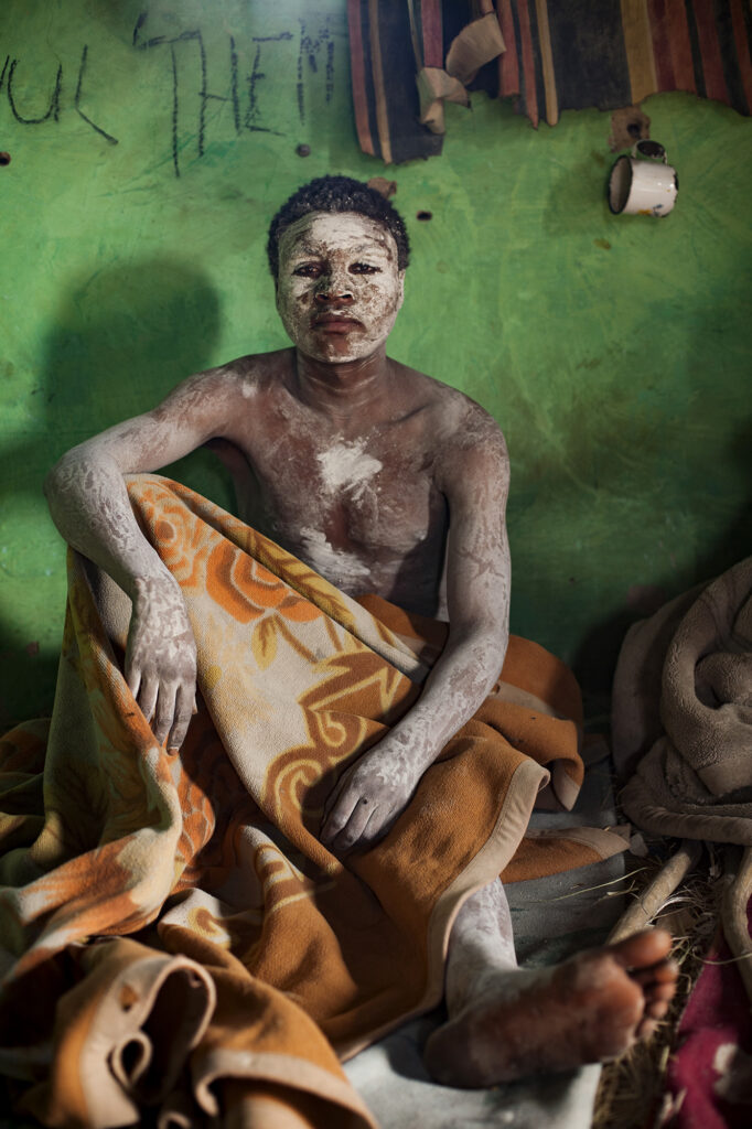 Color portrait of AmaXhosa initiate inside a traditional hut